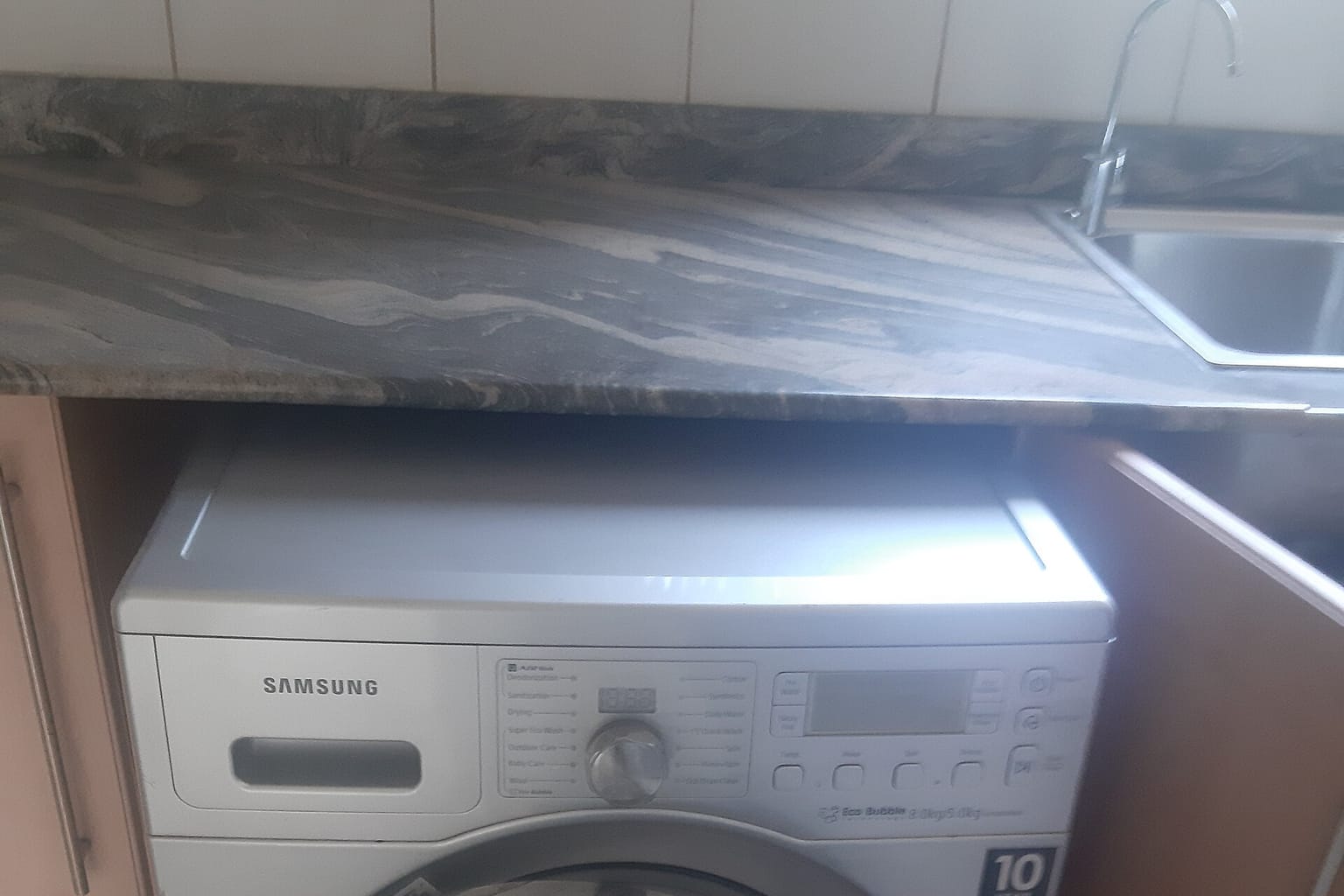 Washing machine on a hand truck beside an open box truck